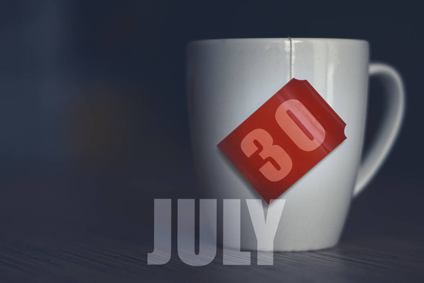 30 de julio. Día 30 del mes, taza de té con fecha en la etiqueta de la bolsa de té. verano mes, día del año concepto. - Foto, Imagen