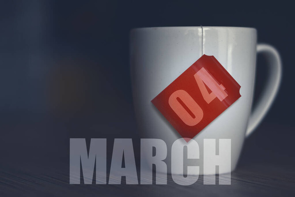 4 Mart. Ayın dördüncü günü, çay poşetinden alınmış etiketli çay kupası. Bahar ayı, yılın günü konsepti.. - Fotoğraf, Görsel