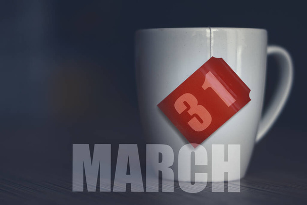 31 de marzo. Día 31 del mes, taza de té con fecha en la etiqueta de la bolsa de té. mes de primavera, concepto del día del año. - Foto, Imagen