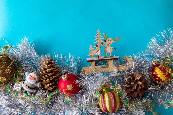 Новорічна композиція ялинкових прикрас, мішури, іграшок. Різдвяний фон з атрибутами свята на синьому фоні. Вільний простір для дизайну
.  - Фото, зображення