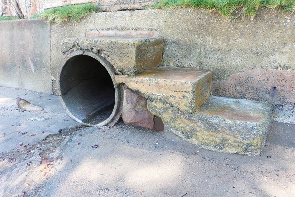 Concrete sewer with stairs to the beach. Water drainage hole. - Photo, Image