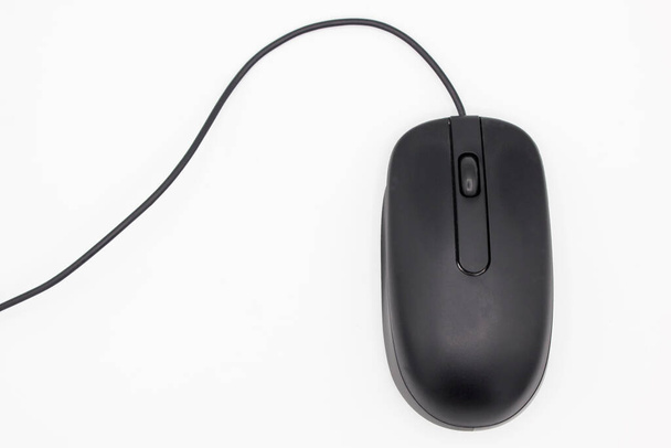 Vue supérieure d'une souris d'ordinateur noire avec roue et fil sur fond blanc. Pose plate avec espace pour le texte - Photo, image