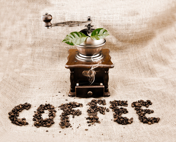 Vintage koffie grinder en teken koffie uit koffie korrels - Foto, afbeelding
