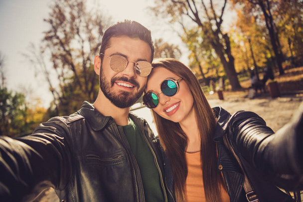 Portrait of positive two hipsters girl guy make selfie in yellow forest autumn park wear casual jacket - Fotografie, Obrázek