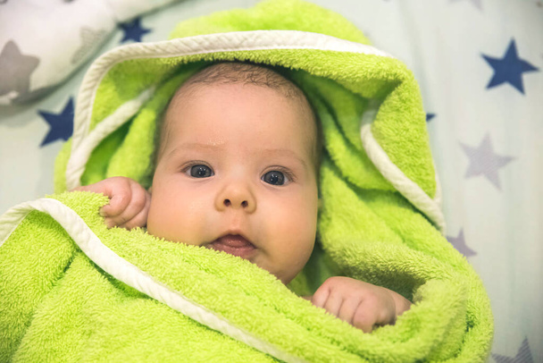 hermoso bebé recién nacido envuelto en una toalla verde después de bañarse - Foto, Imagen