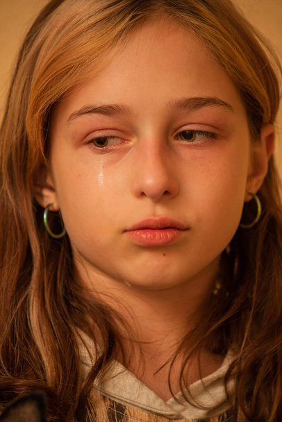 Yanaklarından akan gözyaşlarıyla ağlayan küçük bir kızın portresi. Kız ağlıyor. 9 yaşındaki kız çok üzgün. Gençlik sorunları. 9 ya da 10 yaşında bir kız değişim geçiriyor. Üzüntü. - Fotoğraf, Görsel