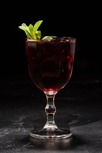 Glass of red wine sangria with mint leaves on black background - Fotoğraf, Görsel