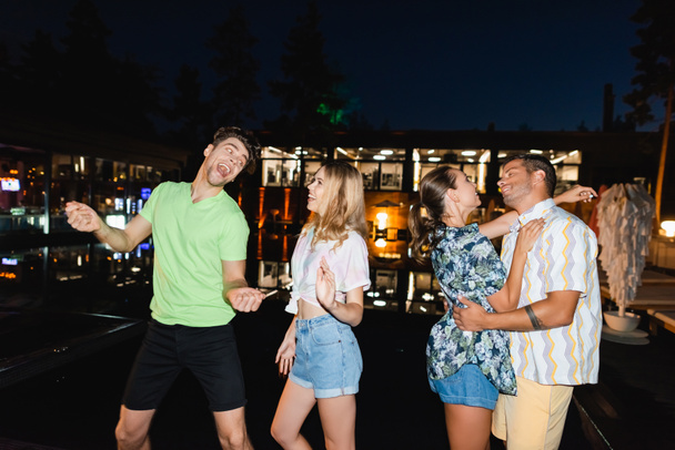 Parejas jóvenes bailando durante la fiesta al aire libre por la noche - Foto, Imagen