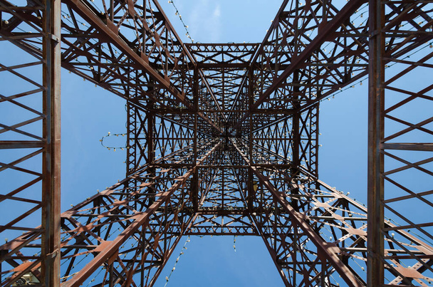 青い空に対する金属構造の塔 - 写真・画像
