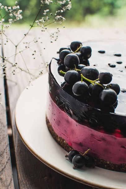 黒スグリのチーズケーキムースケーキ。木のテーブルの上にベリーとおいしいケーキ. - 写真・画像