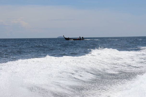 バックグラウンド・ウェーブとスプラッシュ、アジアの熱帯の島々の近くでスピードボートに乗る - 写真・画像