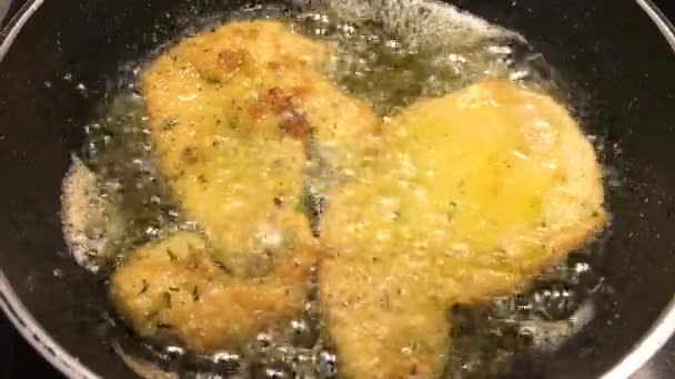 Chicken fillets battered with breadcrumbs and parsley, simmered with oil in the pan, 4k - Footage, Video