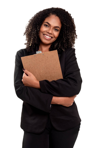 Веселая и улыбающаяся исполнительная черная бразильская женщина изолирована на белом фоне, работает с планшетом и держит ручку. - Фото, изображение