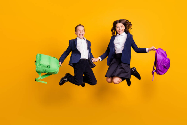 Full length body size view of his he her she attractive small little cheerful ecstatic schoolchildren jumping back to elementary school isolated bright vivid shine vibrant yellow color background - Foto, Imagem