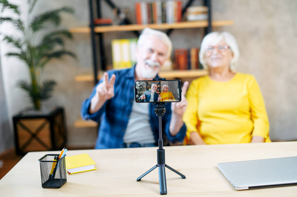 Elderly couple is recording vlogs on the smartphone - Foto, imagen