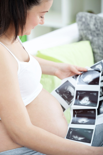 Pregnant woman looking a photo of her Ultrasound - Foto, afbeelding