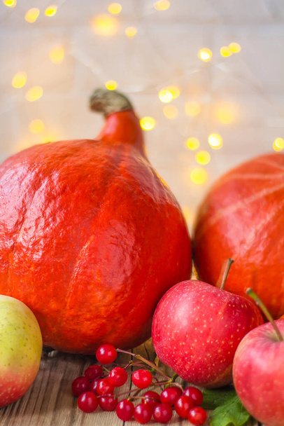 Festive autumn decor of pumpkins and apples on a white brick background with bokeh. The concept of Thanksgiving or Halloween - Valokuva, kuva