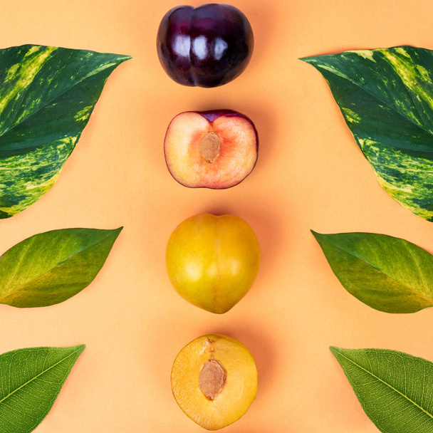 Coloridos frutos de ciruela en el fondo amarillo vista superior - Foto, Imagen