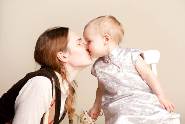 mum kisses the small daughter. maternal love. - Фото, зображення