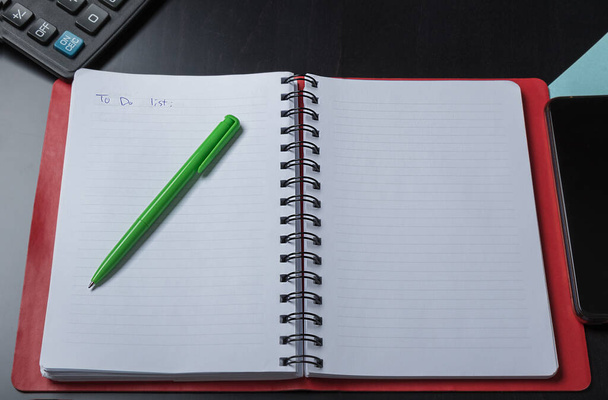 offenes Notizbuch mit Stift für Planungsaufgaben auf dunklem Hintergrund - Foto, Bild
