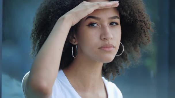 Amerikai afro etnikai lány néz távolba a kezét a homlokát, keres valamit. Találatok, örömök és hullámok. - Felvétel, videó