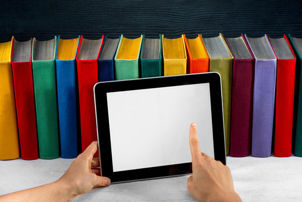 lezen op de Tablet PC met kleurrijke boeken op achtergrond - Foto, afbeelding
