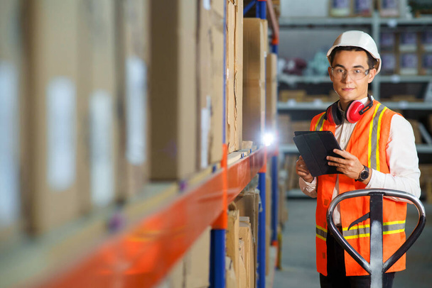 Portrait d'un employé d'entrepôt logistique avec une tablette dans ses mains - Photo, image