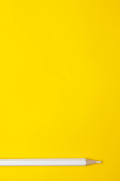 Vertical white sharp wooden pencil on a bright yellow background, isolated, copy space, mock up - Фото, зображення