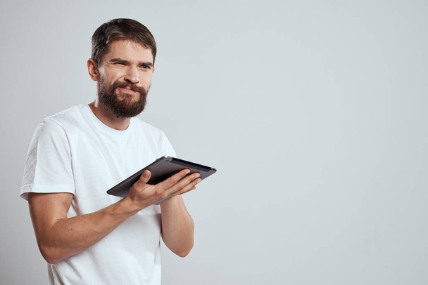 эмоциональный человек с планшетом в руке сенсорный экран новые технологии светлый фон обрезанный вид - Фото, изображение