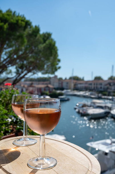 Degustazione di vino rosato freddo locale in estate con porto di barche a vela di Port Grimaud sullo sfondo, Provenza, Var, Francia - Foto, immagini