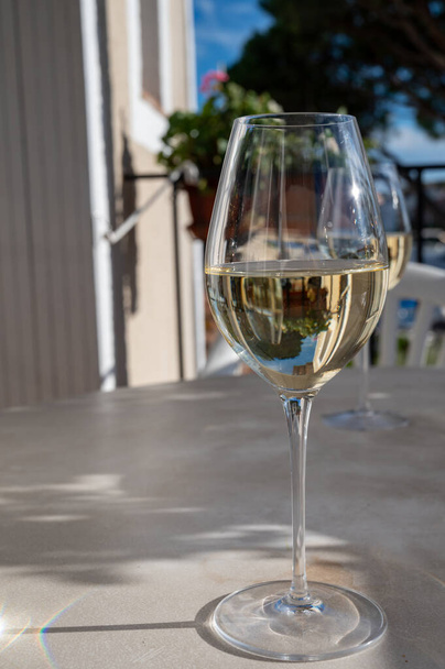 Proeverij van lokale witte wijn op zonnig zomerbalkon in Provence, Frankrijk - Foto, afbeelding
