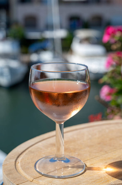 Degustación de vino de rosas frías locales en verano con veleros remanso de Port Grimaud en el fondo, Provenza, Var, Francia - Foto, Imagen