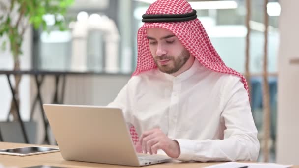 オフィスのカメラでノートパソコンの笑顔を持つアラブビジネスマン  - 映像、動画