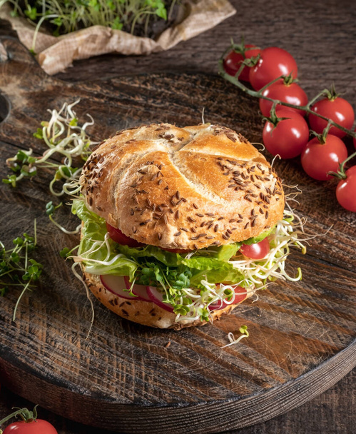 Vegetarian burger with broccoli, radish and fenugreek microgreens on a rustic background - Photo, Image