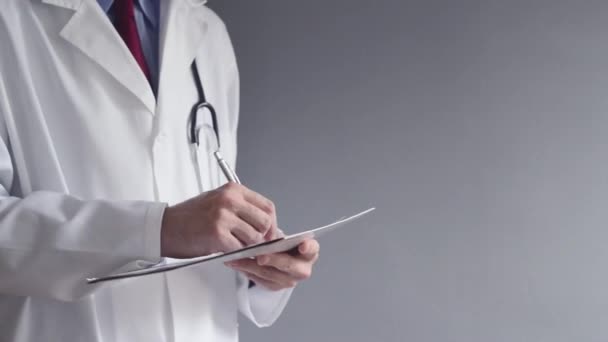 Male doctor is writing RX prescription while standing. Health care professional writing. - Séquence, vidéo