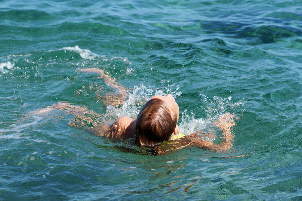 unavená dospívající dívka plave na zádech v moři. - Fotografie, Obrázek