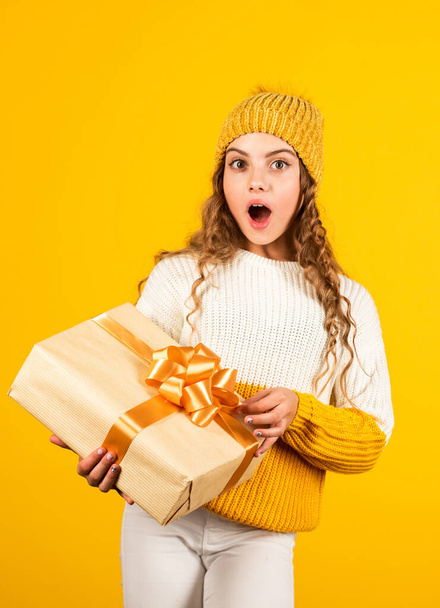 Shopping mall. Birthday girl. Happy holidays. Xmas gift shopping. Gift package. Cherished dreams. Boxing day. Teen girl hold gift box. Kid hold present box yellow background. Purchase and delivery - 写真・画像