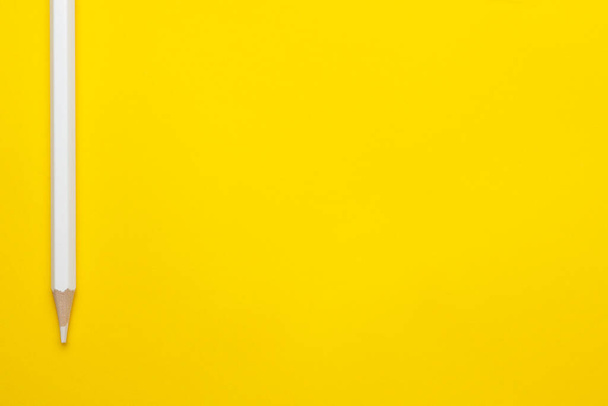Horizontal white sharp wooden pencil on a bright yellow background, isolated, copy space, mock up - Foto, imagen