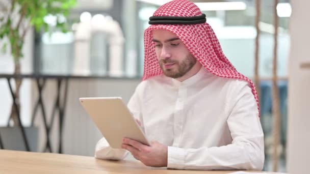Empresario árabe profesional serio que usa la tableta en oficina  - Imágenes, Vídeo