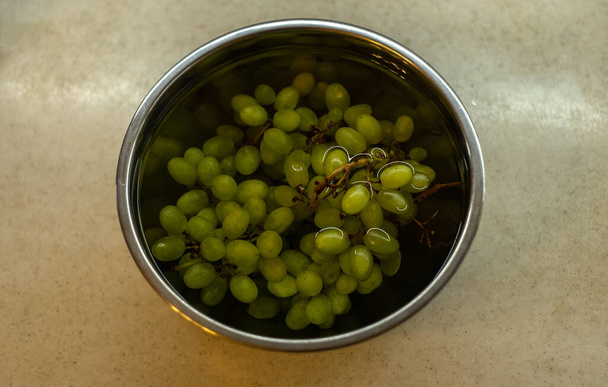 Uvas verdes en la cocina en un recipiente de metal - Foto, imagen