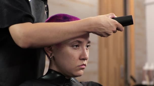 Peluquería corta el cabello corto con un clipper Salón de casa durante la epidemia - Imágenes, Vídeo