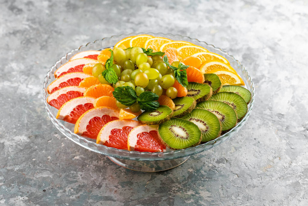 Composition alimentaire festive de tranches de fruits avec des feuilles de menthe  - Photo, image