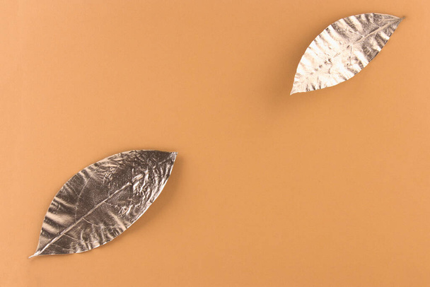Leaves painted in gold on an orange background. Golden autumn concept. - Foto, imagen