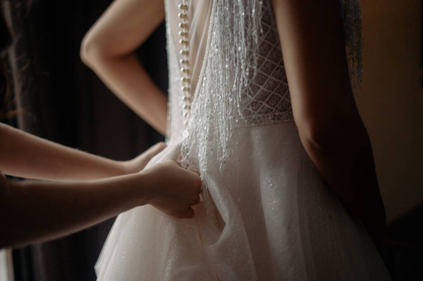 Bride white lace wedding dress. Bride help put on the wedding dress - Zdjęcie, obraz