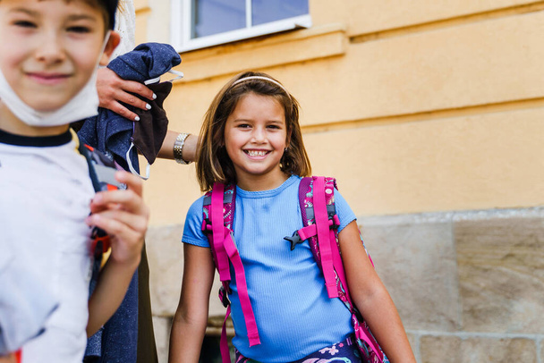 Caucasico madre prendere i suoi figli a scuola in estate giorno - Prima elementare alunni bambino e ragazza andando a classe - Foto, immagini