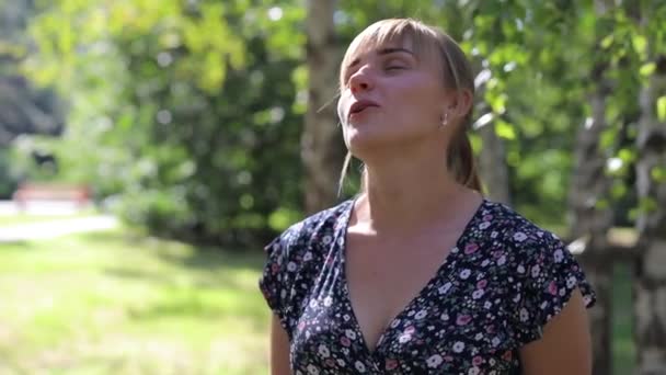 Blondýny žena dýchá vzduch v parku - Záběry, video
