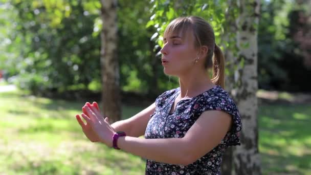 Kobieta uprawia jogę na świeżym powietrzu w parku - Materiał filmowy, wideo