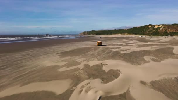 Dron letí přes přestavěný karavan uvízl v písku na pláži - Záběry, video