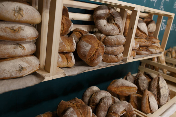 Fresh baked goods are beautifully arranged on display in wooden crates. - Valokuva, kuva