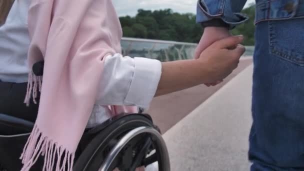 Manos unidas de hija y madre en silla de ruedas - Imágenes, Vídeo
